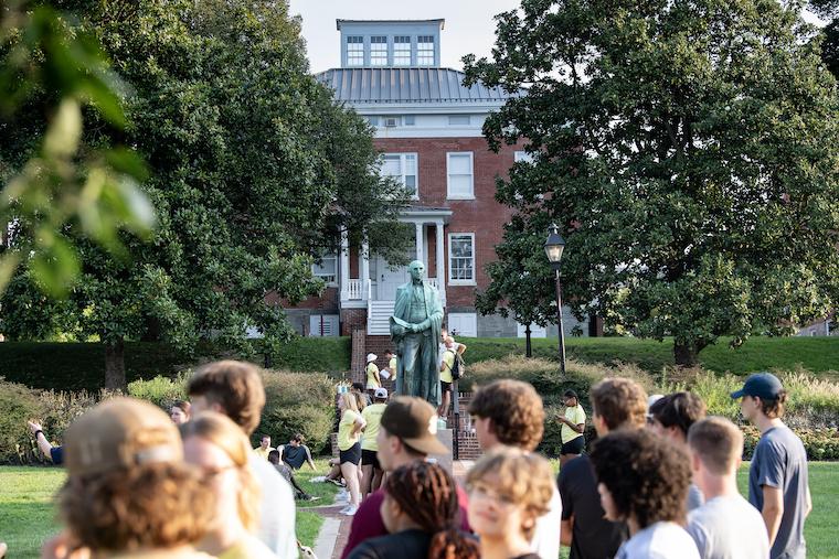 Washington College students pass in front of a statue of George Washington on the Campus Green. 